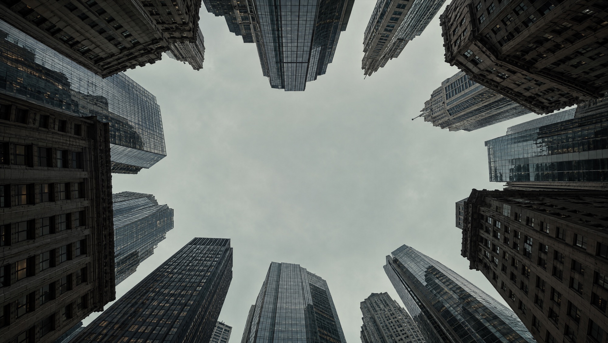 Looking up at a ring of skyscrapers around an opening of sky